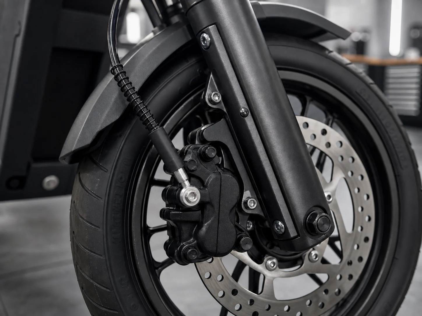Illustrative hydraulic brake hose connection at an electric scooter front brake caliper