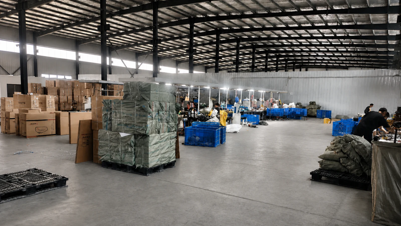 Wide interior view of the ChiZe production facility with packing boxes, blue crates and active workstations