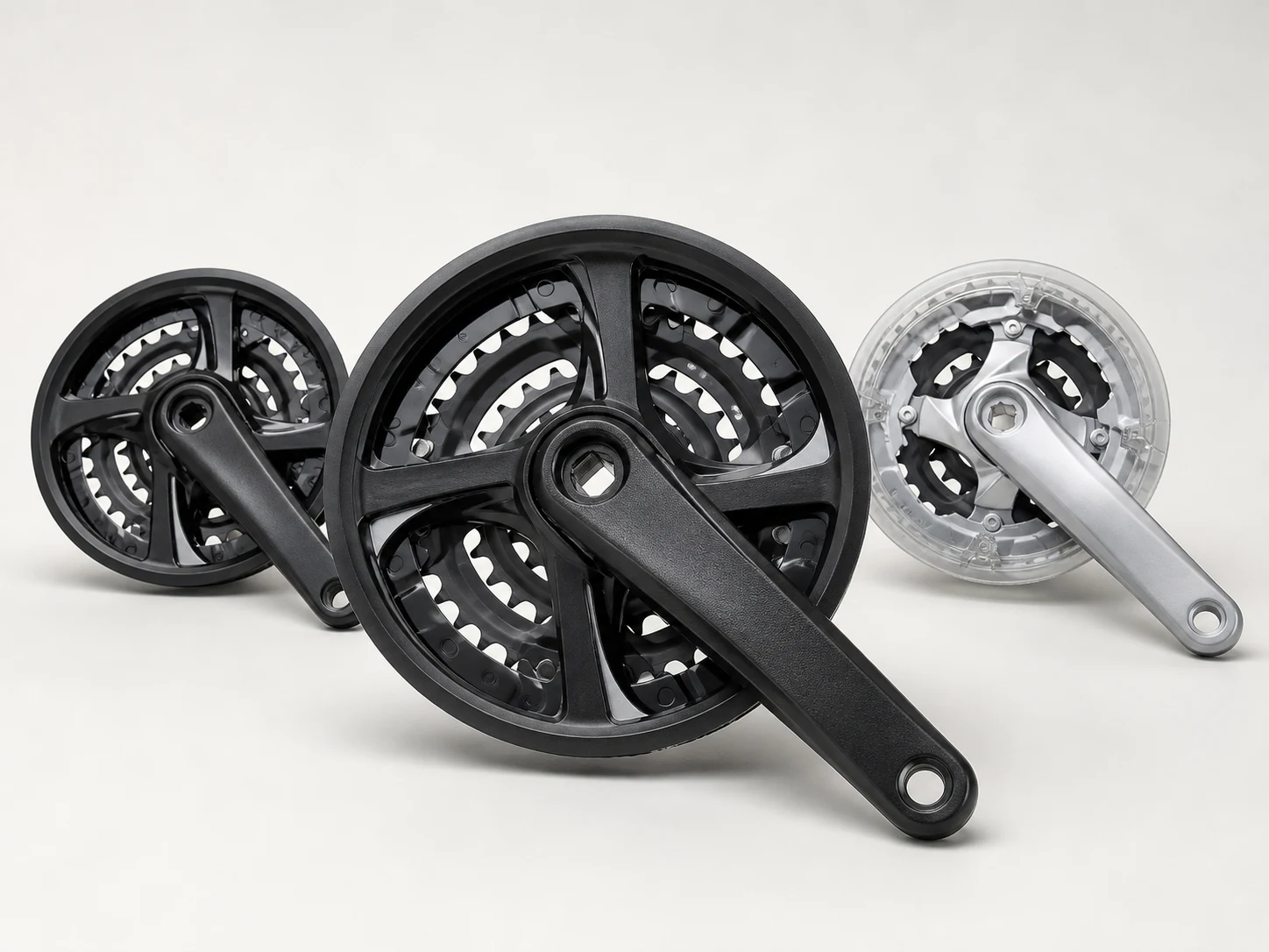 Unbranded black MTB triple crankset family on a neutral studio background